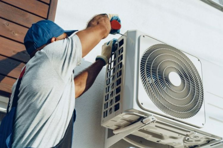 a man repairing an AC